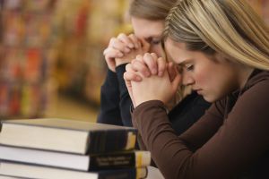 Two women praying in library