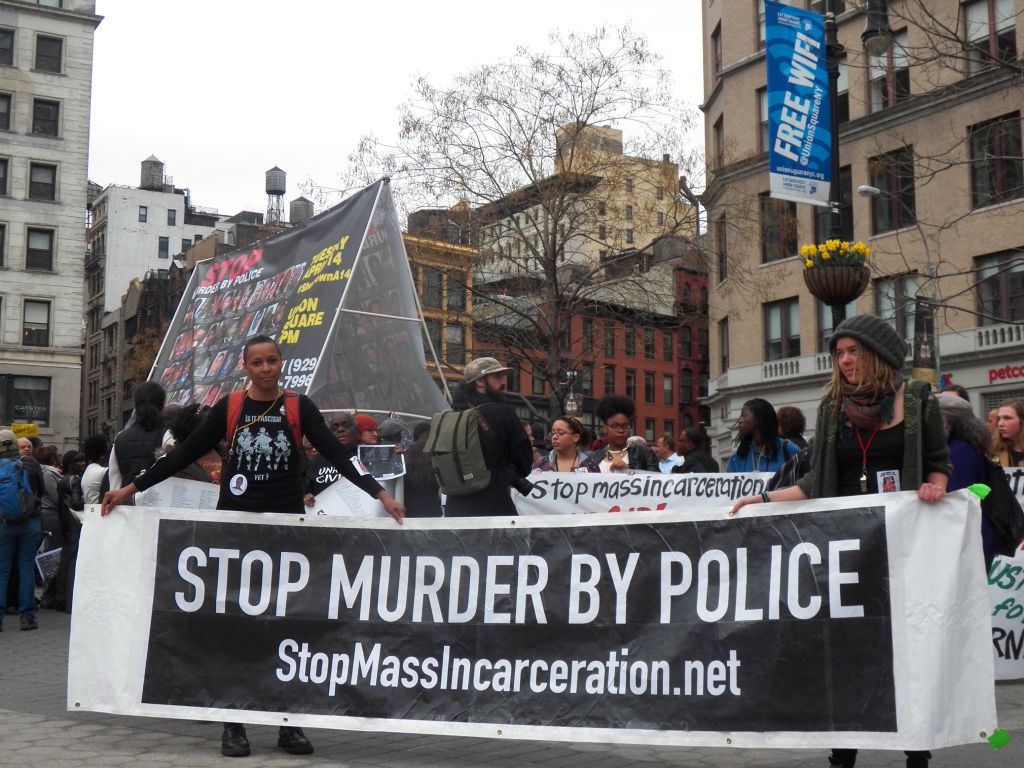 Members of 'Stop Mass Incarceration' carry banner 'Stop...