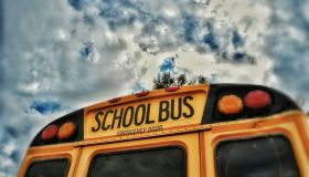Close-Up High Section Of School Bus Against Clouds