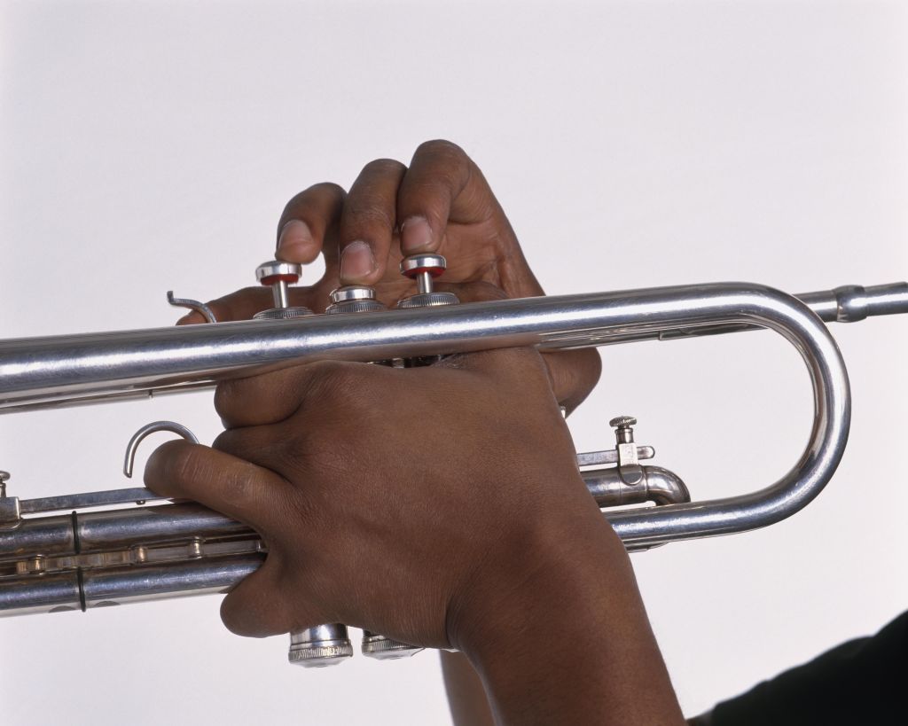 Young man's hands playing jazz trumpet, close-up