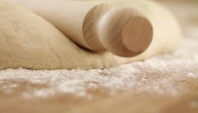 Close up of rolling pin on dough