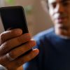 Man using smart phone, responding to text messages