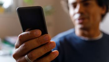 Man using smart phone, responding to text messages