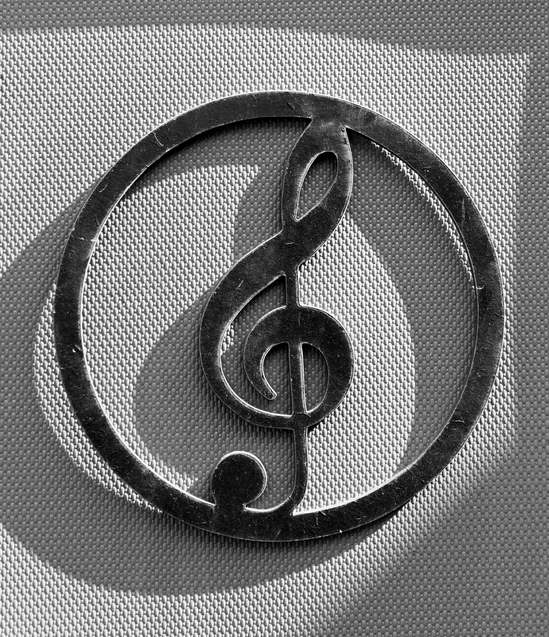 black and white iron treble clef sign on the wall