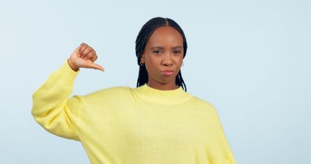Thumbs down, portrait and hands of woman in studio for rejection of bad news, complaint and no feedback on blue background. African model show emoji sign for review of wrong decision, icon or failure