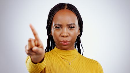 No finger, black woman and angry portrait with protest, caution and wrong hand sign in a studio. Stop, white background and serious African female person with refuse, rejection and forbidden gesture