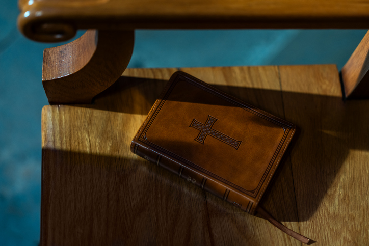 Leather Bible with Cross on Wooden Seat