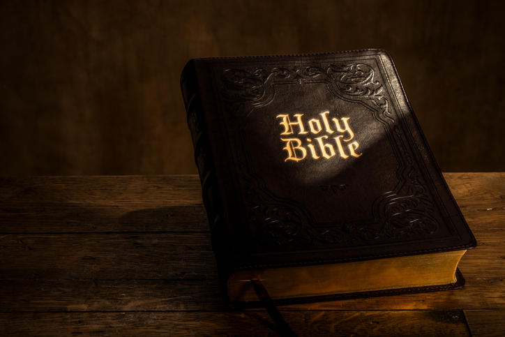 Holy Bible on Wooden Table with Dramatic Lighting