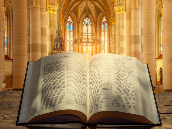 Open Bible in Cathedral with Stained Glass
