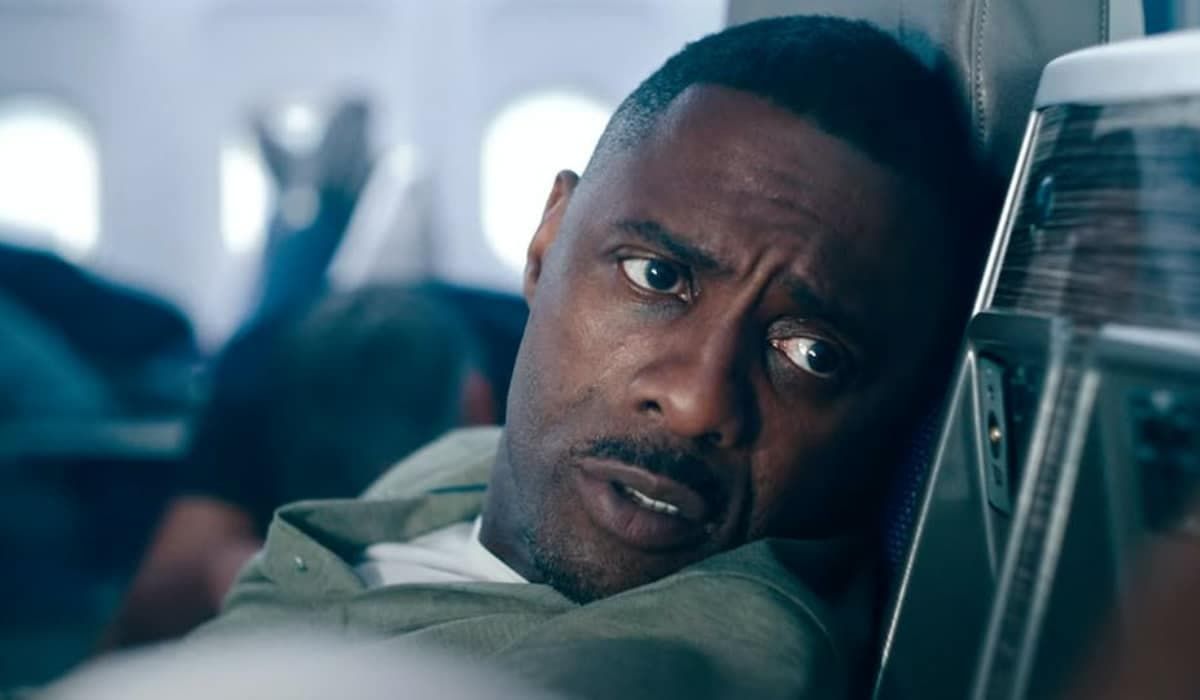 A close-up portrait of a serious-looking Black man with a pensive expression, sitting in what appears to be a vehicle.